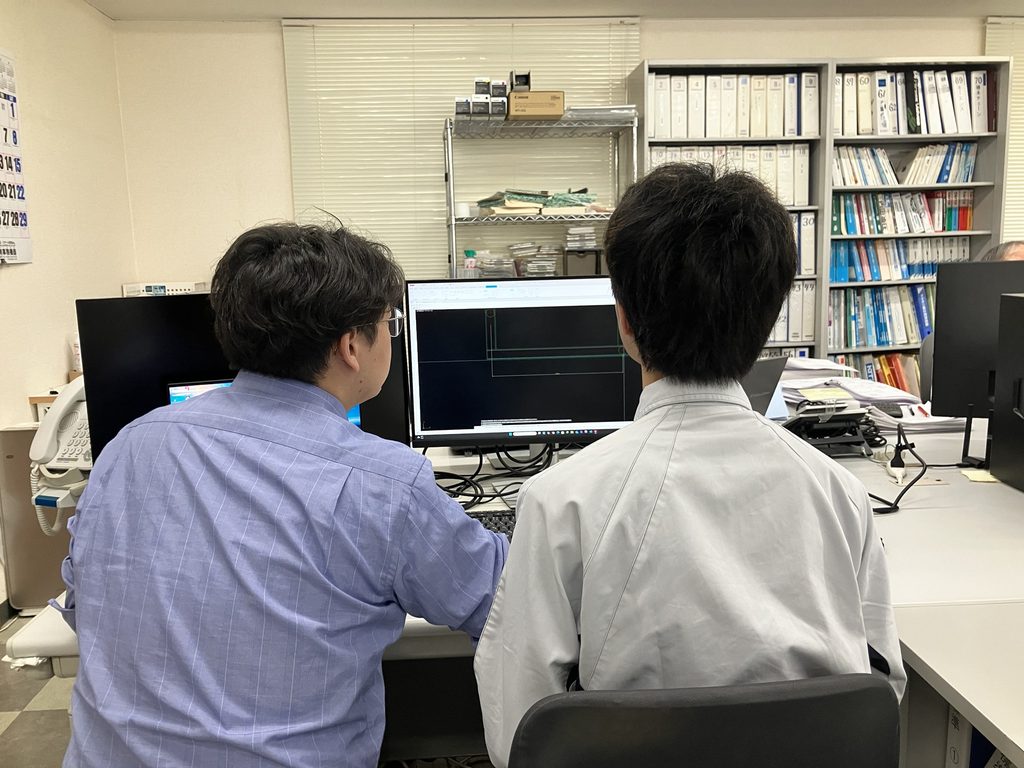 インターンシップで社員の指導を受けながらCADを使った機械設計を体験する学生